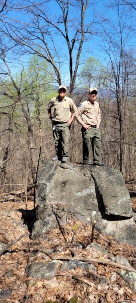 State Park Rangers standing on a rocky boulder where trail will be built.