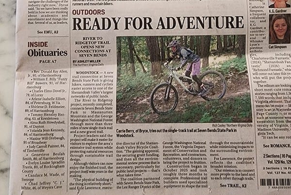 Front page of the Daily News-Record with the headline "Ready for Adventure," featuring a photo of Kyle Lawrence beside a trail sign at Seven Bends State Park and a mountain biker riding the new singletrack.